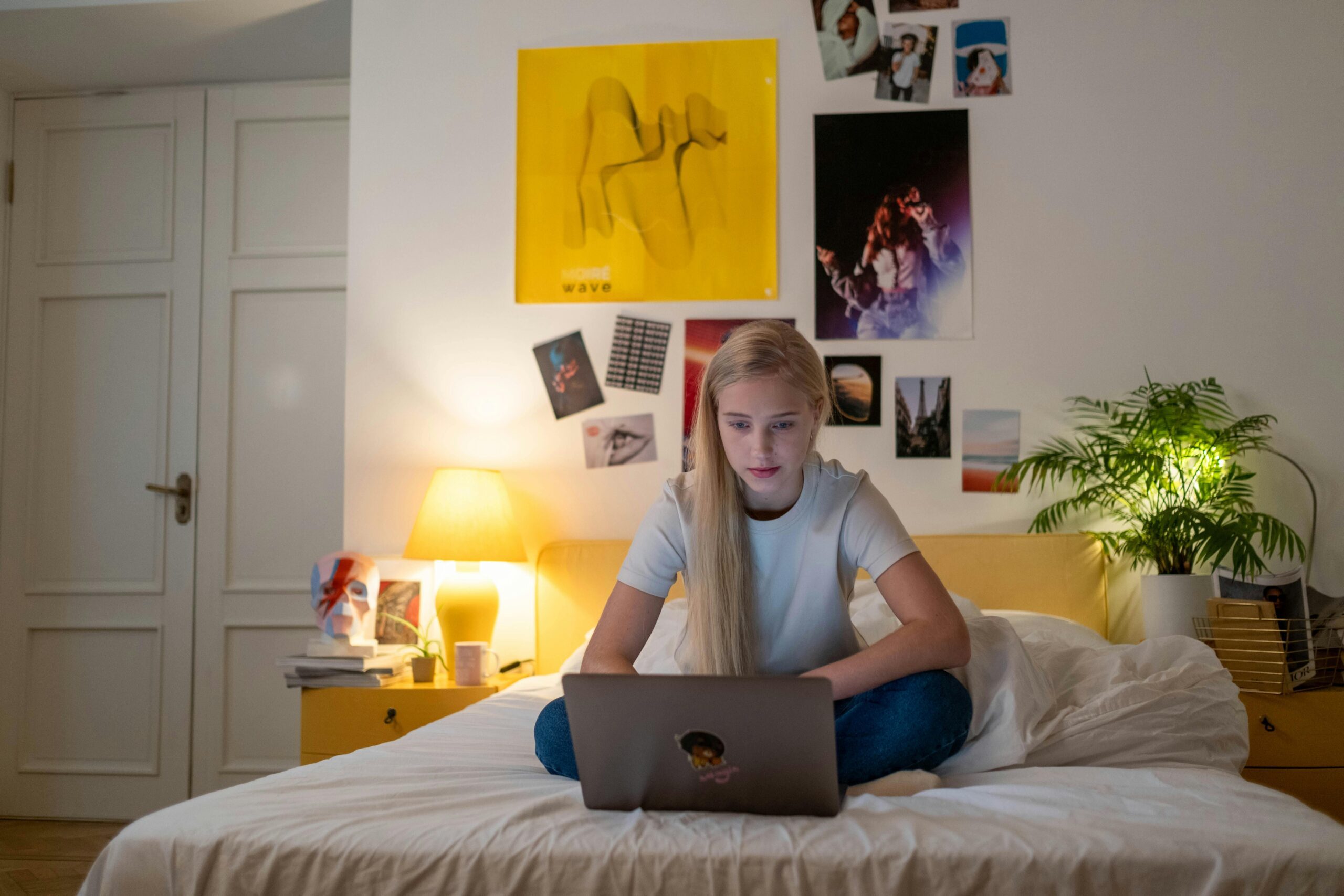 Girl on her laptop learning to sing or play guitar online.