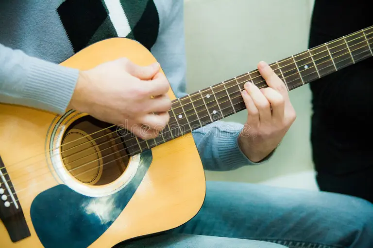 acoustic guitarist playing a barre chord