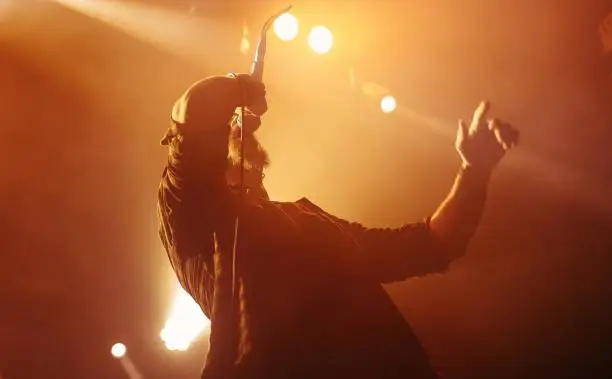 Singer onstage washed in warm lights