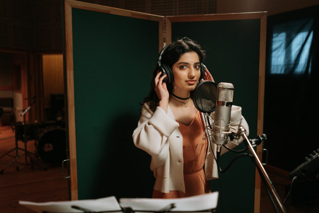 Singer with headphones on in the sutudio getting ready to record. 